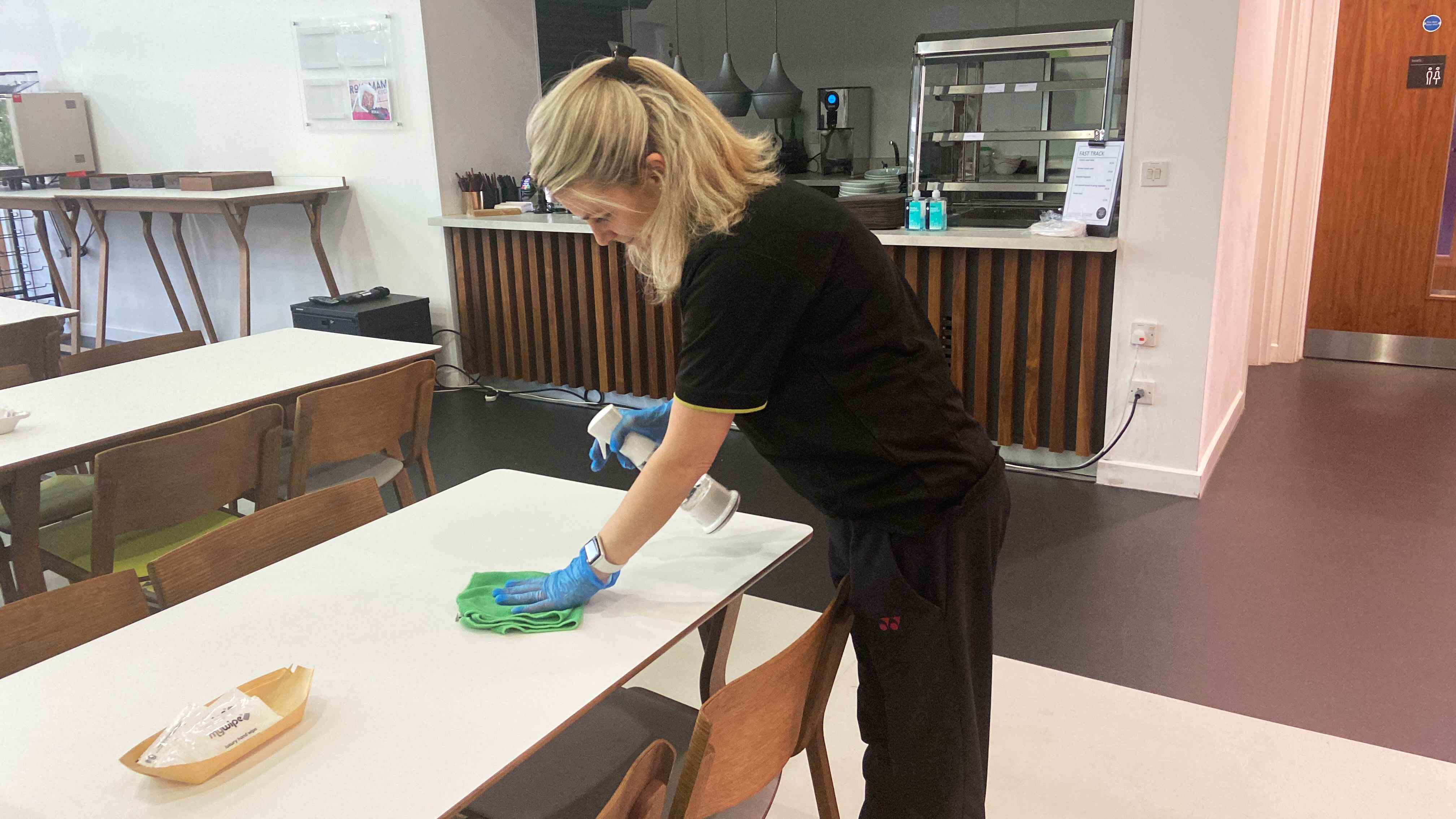 Tatry Group operative sanitising a canteen table