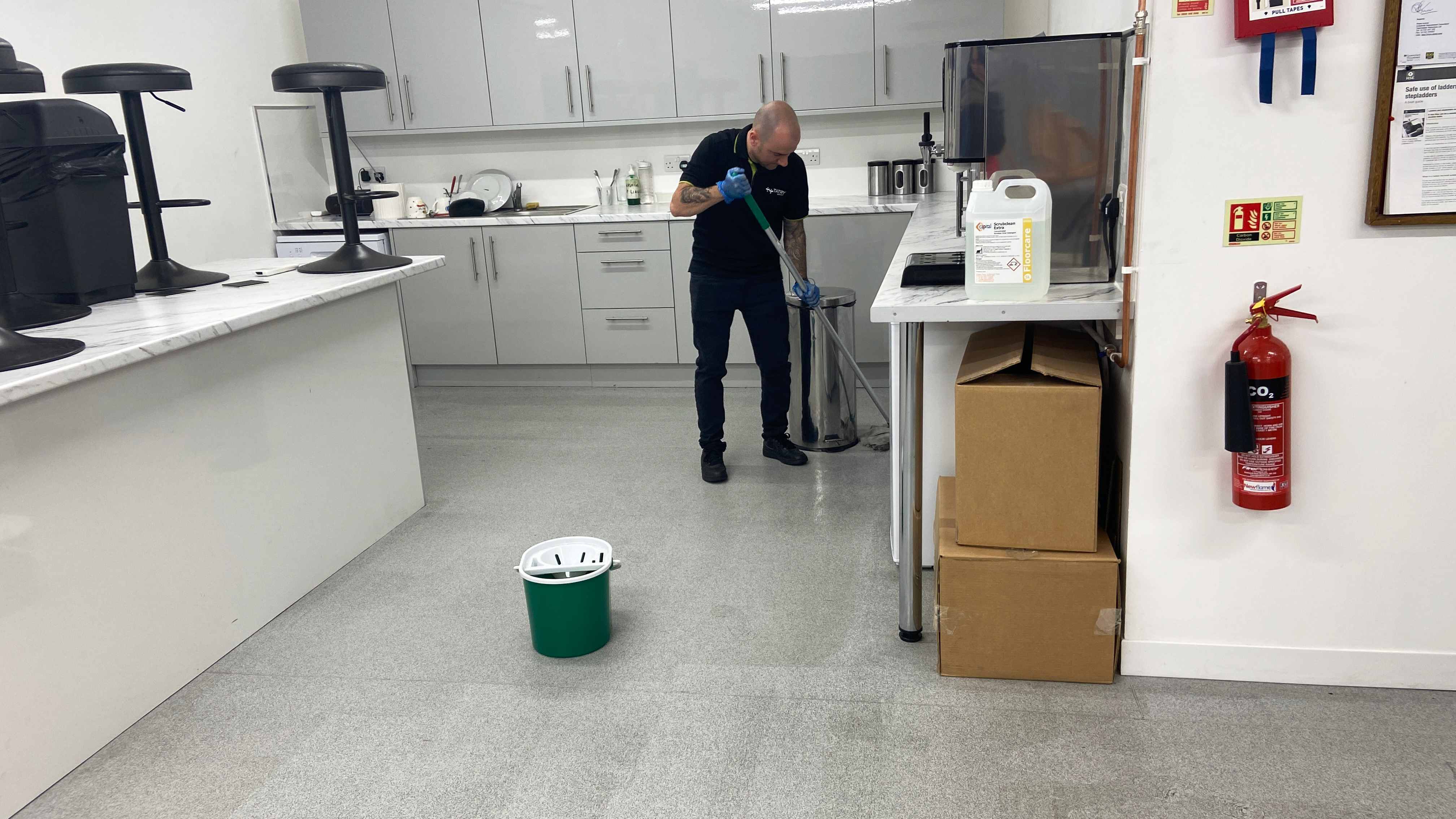Operative mopping an office kitchen floor