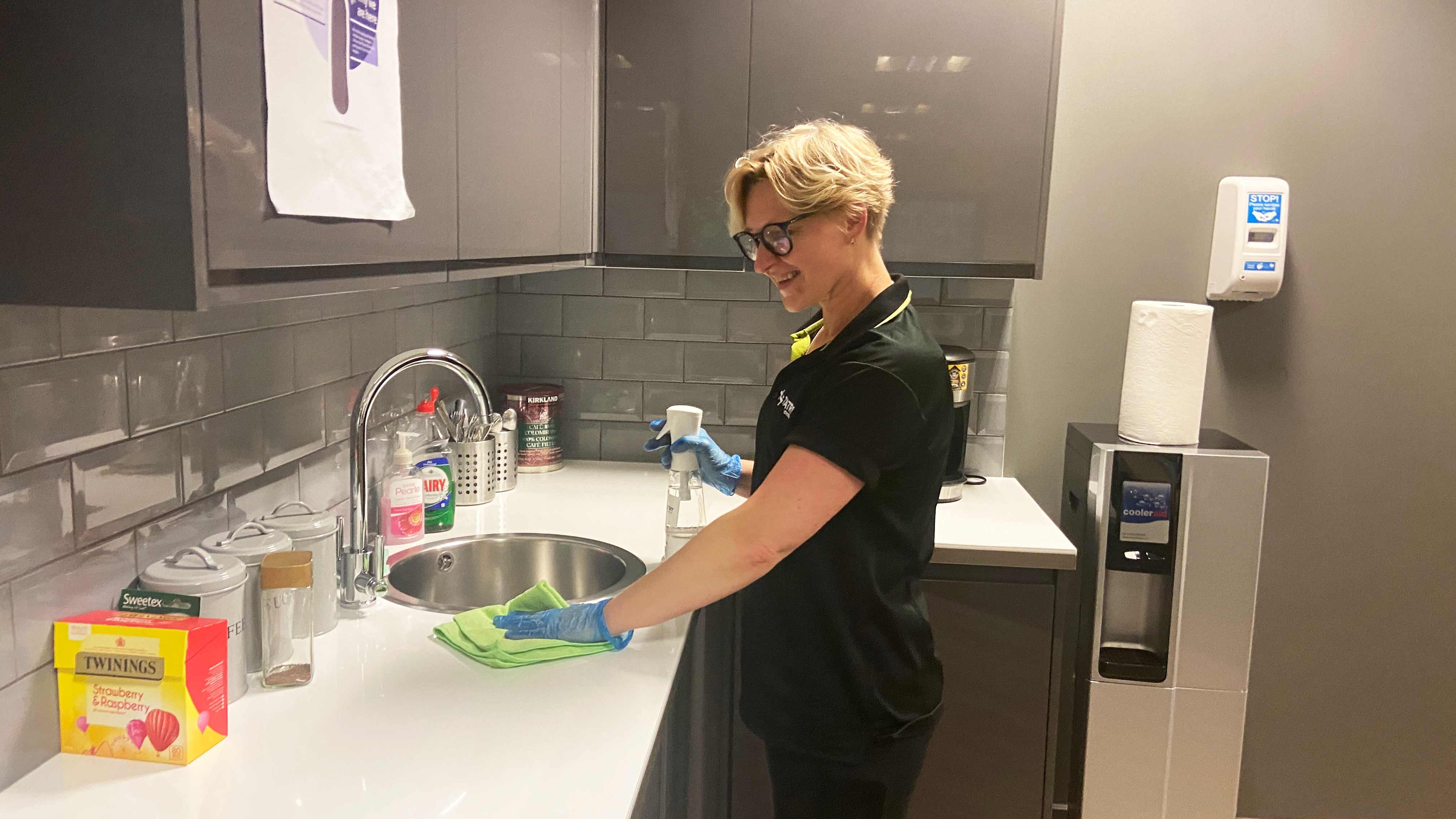 Team member cleaning an office kitchen